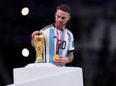 Brighton and Hove Albion midfielder Alexis Mac Allister of Argentina touches the World Cup trophy during the award ceremony