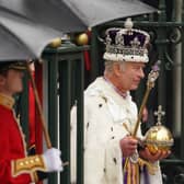 King Charles III, wearing the Imperial State Crown, leaves Westminster Abbey in central London following his coronation ceremony.