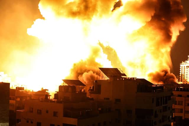 A ball of fire explodes above buildings in Gaza City as Israeli forces shell the Palestinian enclave (Photo by MAHMUD HAMS/AFP via Getty Images)