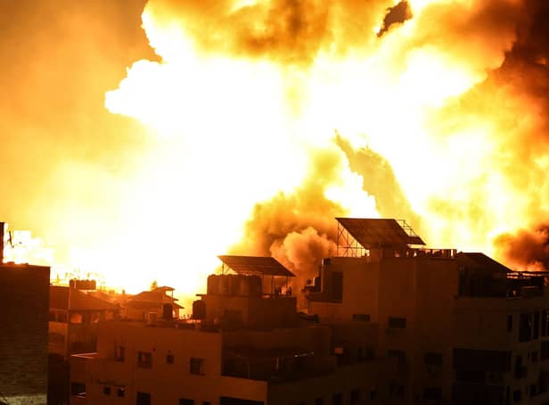 A ball of fire explodes above buildings in Gaza City as Israeli forces shell the Palestinian enclave (Photo by MAHMUD HAMS/AFP via Getty Images)