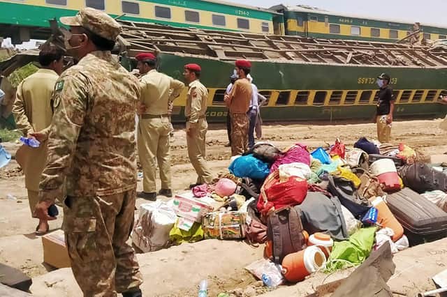 Security personnel stand at the site of a train accident in Daharki area of the northern Sindh province (Photo by AFP via Getty Images)