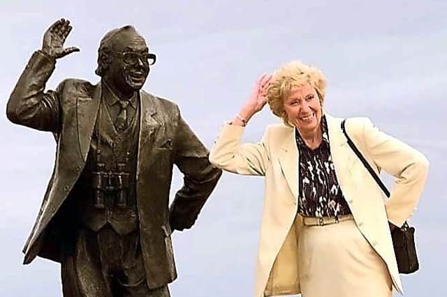 Joan Morecambe, the widow of comedian Eric Morecambe, poses next to his statue.