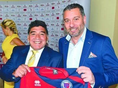 Superstar Diego Maradona poses with a Biggleswade United shirt alongside club chairman Guillem Balague.