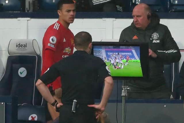 Referee Craig Pawson watches an incident on the VAR screen after giving a penalty which he later rescinds during the match between West Bromwich Albion and Manchester United.