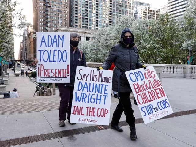 Women walk with signs through the Millennium Park as they protest during a rally on April 15, 2021 in Chicago, Illinois. The rally is held in protest of the killing of 13-year-old Adam Toledo by a Chicago Police officer on March 29th.