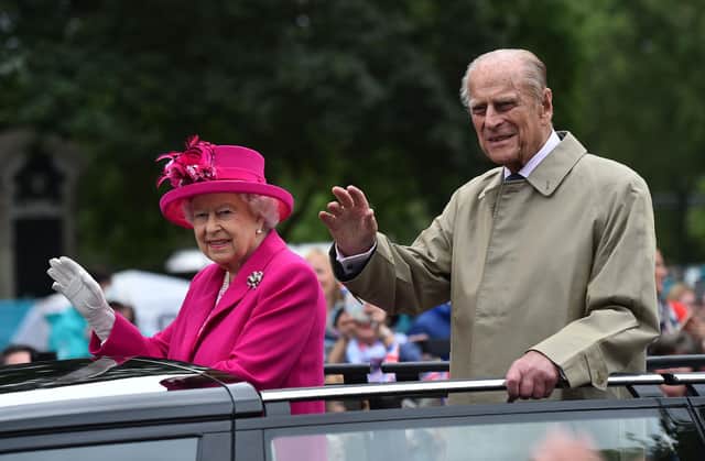 The Queen and Prince Philip pictured waving to guests at a street party outside Buckingham Palace in 2016, as part of Queen Elizabeth II's official 90th birthday celebrations (Getty).
