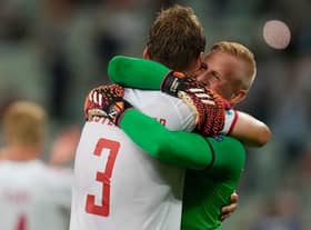 Denmark's goalkeeper Kasper Schmeichel celebrates with defender Jannik Vestergaard. (Photo by DARKO VOJINOVIC/POOL/AFP via Getty Images)