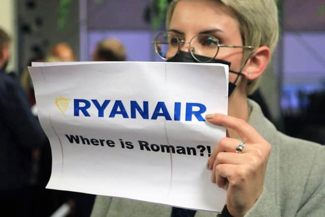 A woman stands with a poster reading 'Where is Roman?!' in the arrival area as passengers disembark from the Ryanair passenger plane from Athens that was intercepted and diverted to Minsk on the same day by Belarus authorities on 23 May (Photo: PETRAS MALUKAS/AFP via Getty Images)