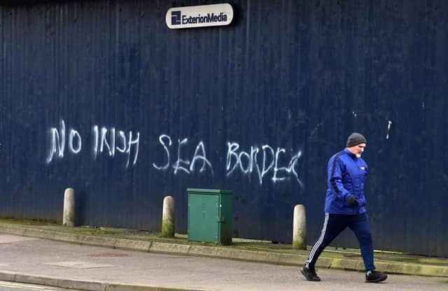 A man walks past freshly painted loyalist graffiti in Belfast city centre on January 31, 2021(Photo by Charles McQuillan/Getty Images)