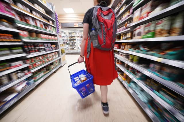 A shopper walking through the aisle of a Tesco supermarket (Picture: Yui Mok/PA Wire)