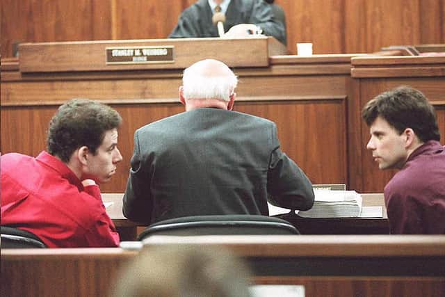 Erik (L) and Lyle (R) Menendez conversing in the courtroom during a 1995 hearing in Los Angeles (Photo: KIM KULISH/AFP via Getty Images)