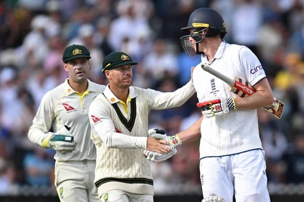 Australia's David Warner (C) shakes the hand of England's Zak Crawley (R) after he loses his wicket for 189 runs on day two of the fourth Ashes cricket Test match between England and Australia at Old Trafford cricket ground in Manchester, north-west England on July 20, 2023. (Photo by Oli SCARFF / AFP) / RESTRICTED TO EDITORIAL USE. NO ASSOCIATION WITH DIRECT COMPETITOR OF SPONSOR, PARTNER, OR SUPPLIER OF THE ECB (Photo by OLI SCARFF/AFP via Getty Images)