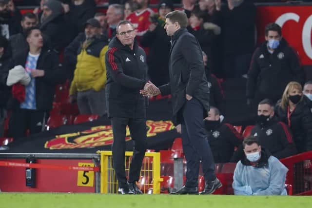 Aston Villa head coach Steven Gerrard, right, shakes hands with Manchester United's interim coach Ralf Rangnick. 