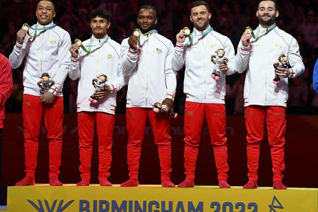 Jake Jarman is second left as England celebrate their gold medal win. (Photo by PAUL ELLIS/AFP via Getty Images).