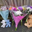 Teddy bears and flowers left at the scene of the triple murder at Petherton Court, Kettering