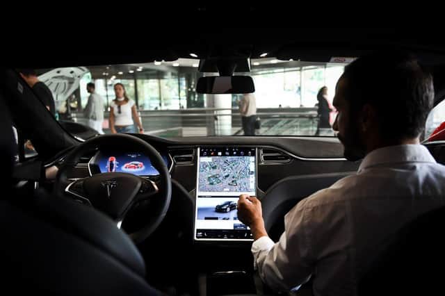 A seller shows the dashboard of the Tesla Model S car at the electric carmaker Tesla showroom of El Corte Ingles store in Lisbon.
