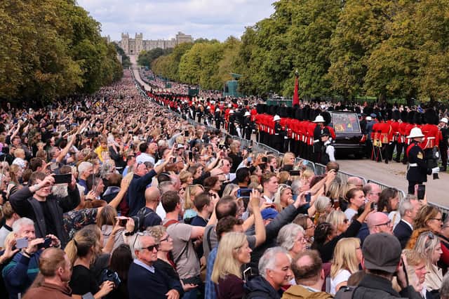 Mourners watch the State Hearse of Queen Elizabeth II as it drives along the Long Walk ahead of the Committal Service for Queen Elizabeth II in Windsor (Photo by Richard Heathcote/Getty Images)