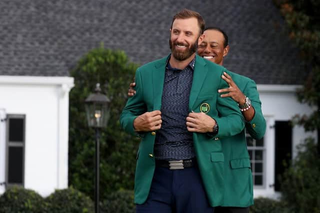 Defending champion Dustin Johnson is awarded the Green Jacket by 2019 Masters champion Tiger Woods.