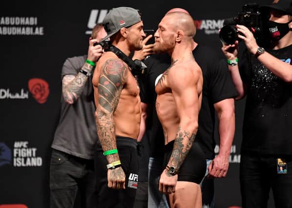 Dustin Poirier and Conor McGregor face off during the UFC 257 weigh-in.