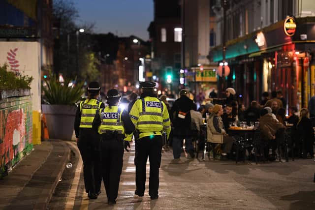 Police officers patrol the streets where customers are enjoying drinks at tables outside the pubs in the Northern Quarter of central Manchester (Photo by OLI SCARFF/AFP via Getty Images)