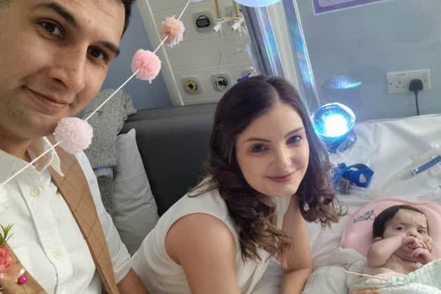 Karim Rezaie, 38, psychological therapist and Louise Rezaie, 30, psychological well-being practitioner pictured on their wedding day with their baby daughter Layla as the bridesmaid (SWNS).
