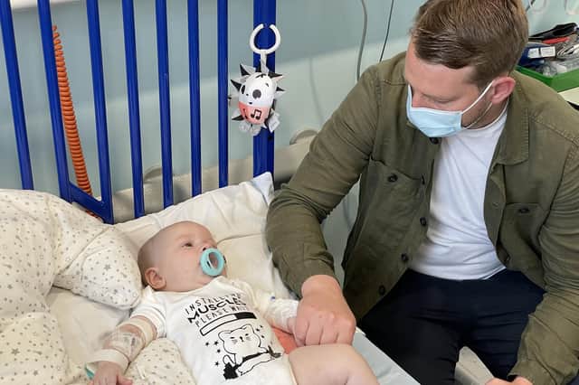 Five-month old Arthur Morgan, pictured in hospital with his dad Reece, has become the first patient in England treated with a potentially life-saving drug on the NHS that can prolong the lives of children with spinal muscular atrophy (image: PA).