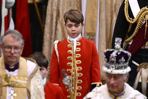 Page of Honour Prince George of Wales and Britain's King Charles III wearing the Imperial state Crown leave Westminster Abbey after the Coronation Ceremonies.