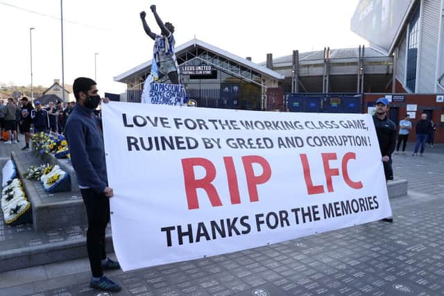 Fans hold up a banner in protest against the European Super League outside Elland Road prior to the Premier League match between Leeds United and Liverpool.