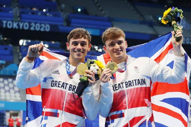 Tom Daley and Matty Lee of Team Great Britain pose for photographers with their gold medals after winning the Men's Synchronised 10m Platform Final on day three of the Tokyo 2020 Olympic Games at Tokyo Aquatics Centre on July 26, 2021 in Tokyo, Japan. (Photo by Clive Rose/Getty Images)