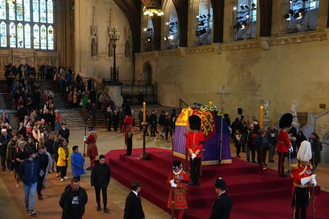 Members of the public file past the coffin of Queen Elizabeth II, lying in state on the catafalque in Westminster Hall.