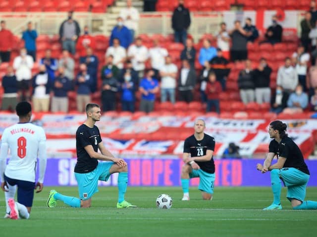 England's midfielder Jude Bellingham (L), Austria's defender Stefan Posch (2L), Austria's midfielder Xaver Schlager (2R) and Austria's striker Marcel Sabitzer take the knee in support of the No Room For Racism campaign ahead of the international friendly football match between England and Austria at the Riverside Stadium.