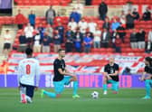 England's midfielder Jude Bellingham (L), Austria's defender Stefan Posch (2L), Austria's midfielder Xaver Schlager (2R) and Austria's striker Marcel Sabitzer take the knee in support of the No Room For Racism campaign ahead of the international friendly football match between England and Austria at the Riverside Stadium.