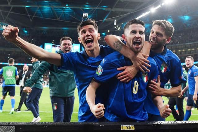 Jorginho of Italy celebrates with Matteo Pessina and Domenico Berardi after scoring their side's winning penalty against Spain.