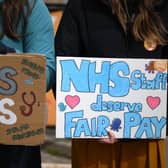 People hold placards calling for fairer pay on a picket line outside Great Ormond Street Hospital. (Picture: Daniel Leal / AFP via Getty Images)