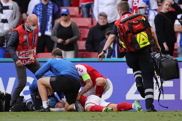 Denmark's midfielder Christian Eriksen receives medical attention after collapsing on the pitch during the UEFA EURO 2020 Group B football match between Denmark and Finland.