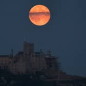 The full moon will be most visible in the UK on Thursday evening, appearing with a colourful glow much like this one which lit up the sky behind St Michael's Mount in Marazion near Penzance on June 28, 2018 (Picture: Getty Images)