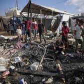 Palestinians inspect the damage at a tent area in the courtyard of Al Aqsa Martyrs hospital, hit by an Israeli bombardment on Deir al-Balah. 