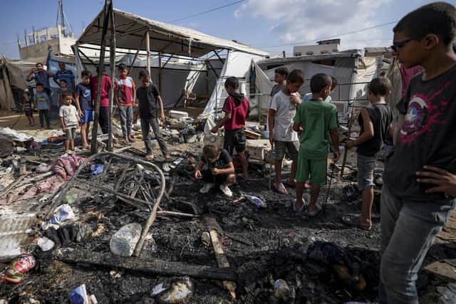 Palestinians inspect the damage at a tent area in the courtyard of Al Aqsa Martyrs hospital, hit by an Israeli bombardment on Deir al-Balah.