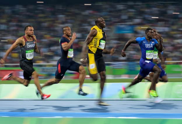Usain Bolt of Jamaica leads the Men's 100 meter final to win ahead of Justin Gatlin of the United States and Andre De Grasse of Canada on Day 9 of the Rio 2016 Olympic Games at the Olympic Stadium on August 14, 2016 in Rio de Janeiro, Brazil.  (Photo by Matthias Hangst/Getty Images)