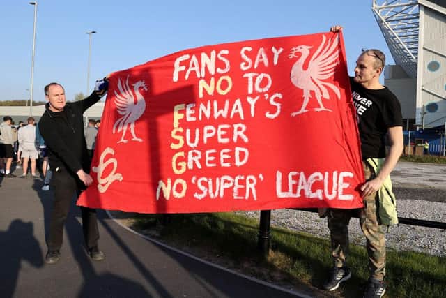 Fans hold up a protest banner against Liverpool FC and the European Super League outside Elland Road prior to the Premier League match between Leeds United and Liverpool.