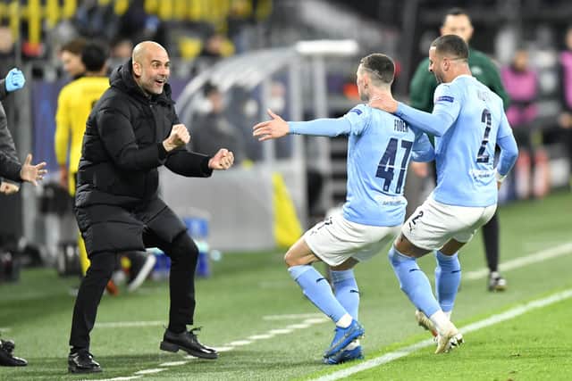 Manchester City manager Pep Guardiola celebrates with goalscorer Phil Foden and Kyle Walker (right).