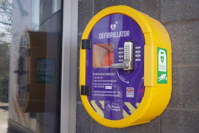 Locked cabinet storing a defibrillator