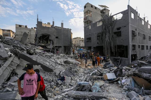 People search through buildings that were destroyed during Israeli air raids in the southern Gaza Strip.