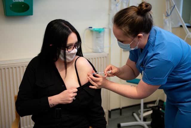 Elle Taylor, 24, an unpaid carer from Ammanford, receives an injection of the Moderna vaccine administered by nurse Laura French
