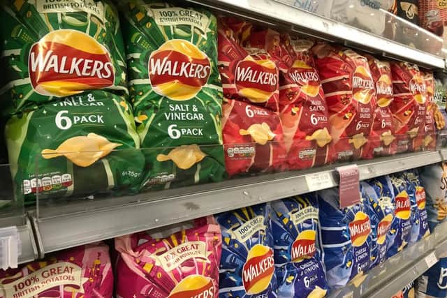 Packets of Walkers crisps on shelves in a supermarket (Shutterstock)