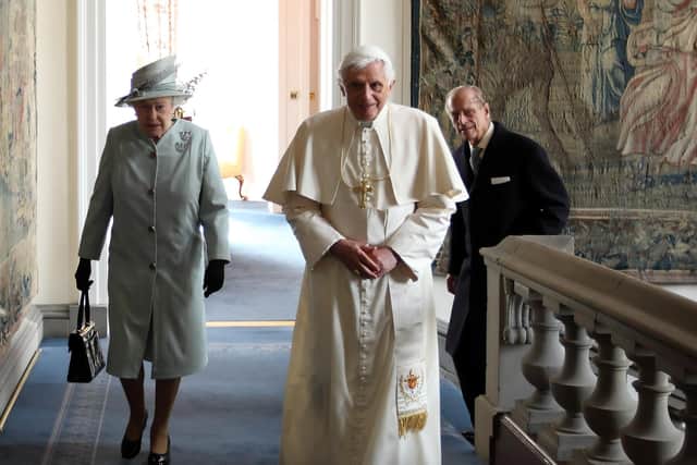 Queen Elizabeth II and Prince Philip, Duke of Edinburgh, walking with Pope Benedict XVI in the Palace of Holyroodhouse.