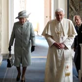 Queen Elizabeth II and Prince Philip, Duke of Edinburgh, walking with Pope Benedict XVI in the Palace of Holyroodhouse.