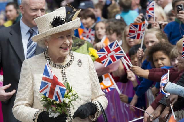 Britain's Queen Elizabeth II is greeted by flag-waving well-wishers as she visits the City Varieties Music Hall in Leeds, West Yorkshire, northern England, on July 19th, 2012 during her diamond jubilee tour. The Queen and the Duke of Edinburgh attended the topping out ceremony for Leeds Arena, where they met construction crews and apprentices before viewing musical and acrobatics performances, during the latest leg of the tour to mark her 60-year reign.