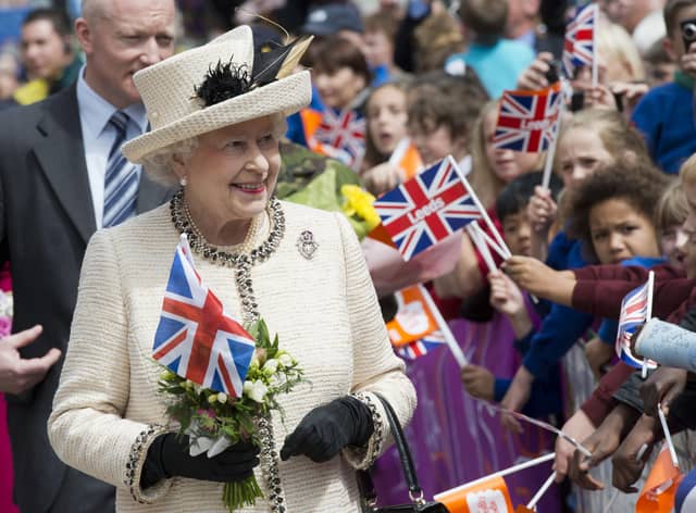 Britain's Queen Elizabeth II is greeted by flag-waving well-wishers as she visits the City Varieties Music Hall in Leeds, West Yorkshire, northern England, on July 19th, 2012 during her diamond jubilee tour. The Queen and the Duke of Edinburgh attended the topping out ceremony for Leeds Arena, where they met construction crews and apprentices before viewing musical and acrobatics performances, during the latest leg of the tour to mark her 60-year reign.