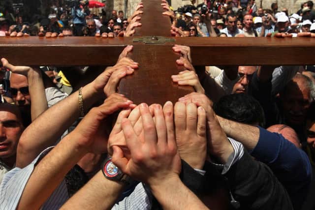 Christians in Jerusalem carry their large wooden cross along the route tradition says Jesus carried the cross on, to mark Good Friday